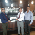 Dr Kularathna handing over 3 laptops to the Minneriya National School Principal